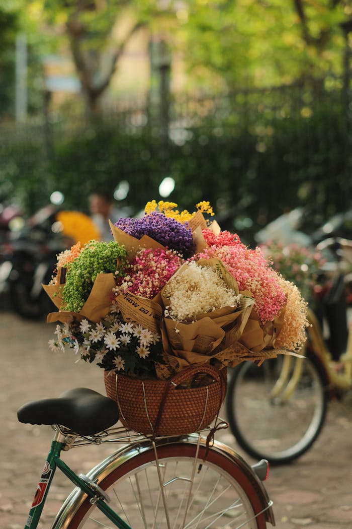 Beautiful bouquets of colorful flowers fill a bicycle basket on a sunny day.